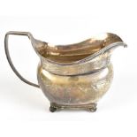 A George III hallmarked silver cream jug of rounded rectangular form with reeded decoration and