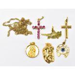 A group of yellow metal pendants including a pendant of the face of Jesus, crosses, etc, combined