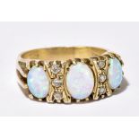 A silver opal and diamond chip ring in the the Victorian manner with three oval opals interspersed