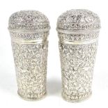 A pair of Indian white metal canisters of tapering oval form with cast decoration depicting