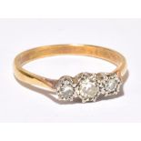 An 18ct yellow gold and platinum tipped illusion set three stone diamond ring, the central stone