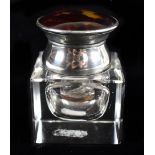 COHEN & CHARLES; a George V hallmarked silver and tortoiseshell mounted clear glass inkwell,