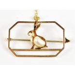 A 1930s 9ct yellow gold open work brooch featuring enamelled hare set with single freshwater baroque