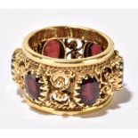 A 14ct yellow gold garnet set broad pierced ring, ring size L 1/2, approx 10.7g.Additional