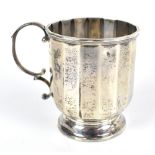 A George V hallmarked silver mug of panelled form raised on circular foot, Birmingham 1928, height