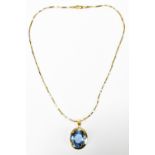 An 18ct yellow gold and blue spinel pendant suspended on an 18ct yellow gold chain, the oval cut