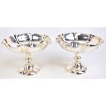 HAMILTON & INCHES; a pair of late Victorian hallmarked silver pedestal bowls of floral form raised