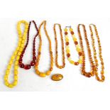 A collection of amber style jewellery to include three strands of beads, assorted glass beads,