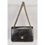 CHANEL; a double flap alligator jumbo black leather shoulder bag with gold tone hardware, CC turn-