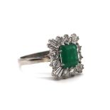 A modern 18ct white gold emerald and diamond ring, the central claw set emerald weighing approx 1.