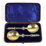 HENRY HOLLAND; a cased pair of Victorian hallmarked silver gilt apostle spoons with foliate stem and