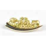 An African yellow metal brooch featuring elephants and lions upon a tusk, the central elephant set