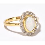 A yellow metal opal and diamond ring, the oval opal approx 8 x 5mm, set within a border of 16 tiny