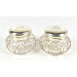 JAMES WILLIAM BENSON; a pair of Victorian hallmarked silver lidded clear cut glass vanity jars, both