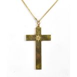 A 9ct yellow gold cross pendant centred with a diamond weighing approx 0.10ct and suspended on a