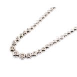 An 18ct white gold and diamond set graduated Riviera necklace, set with seventy-five round brilliant