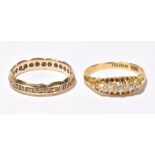 An 18ct yellow gold five stone graduated diamond ring, size P and a yellow metal eternity ring, size