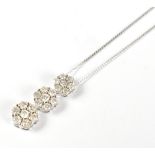 A 9ct white gold diamond pendant set with three graduated hexagonal conjoined platforms, each set