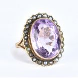 A 9ct yellow gold dress ring centred with an oval amethyst within a border of cultured pearls,