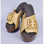 BURBERRY; a pair of sage green leather mules with gold tone buckle hardware, wooden platform and