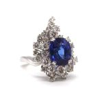 An 18ct white gold diamond cocktail ring, with oval synthetic blue stone within a multi-stepped