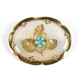 An Edwardian oval yellow metal agate and turquoise brooch, the central panel depicting flower with