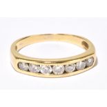 A yellow metal seven stone diamond ring, the round brilliant cut channel set stones totalling approx