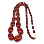 A graduated cherry amber coloured bead necklace, length 72cm, largest bead 32 x 22mm, smallest