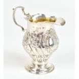 A George III hallmarked silver and later embossed cream jug with loop handle, pinched spout,