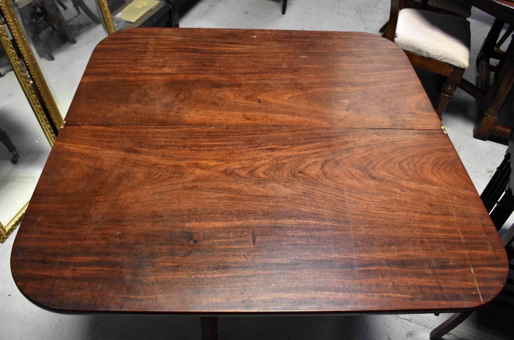 A William IV mahogany fold-over tea table supported on carved and turned tapering legs with brass - Image 4 of 4