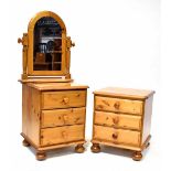 A pair of waxed pine bedside tables, each with three drawers, on bun feet and castors,
