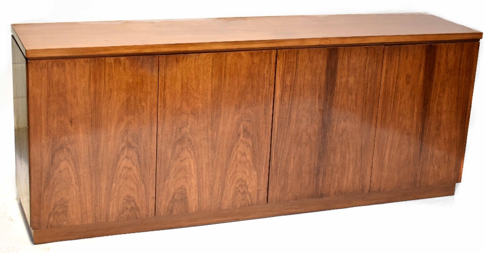 A mid-20th century rosewood sideboard comprising two pairs of cupboard doors,