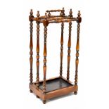 A reproduction stained wood stick stand with turned supports and carrying handle,