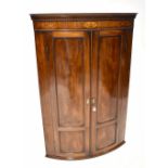 A 19th century mahogany bow-fronted corner cupboard,