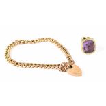 A yellow metal link bracelet with a 9ct gold padlock clasp and a yellow metal fob with amethyst
