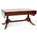 A Regency-style mahogany sofa table on twin pedestal base united by stretchers,