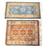 A Turkish hand knotted wool rug with geometric motifs and stylised flowers on a red ground,