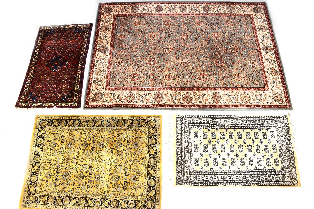 A Kashmir wool rug with floral and scrolling leaf motifs on a green ground within multi-borders,