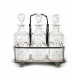 A late 19th century electroplated decanter stand containing three matching cut glass decanters,