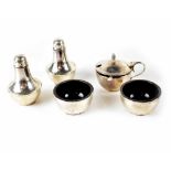 A George V hallmarked silver cruet set of cylindrical form comprising pair of salts,