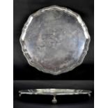 A George V hallmarked silver Chippendale-style salver on four scrolling supports,