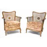 A pair of 1930s bergère armchairs with floral upholstered overstuffed seats, on cabriole legs (2).