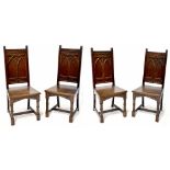 A set of four Gothic Revival oak dining chairs, each with carved arch motif to back panels,