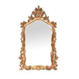 A Rococo-style gilt-framed mirror with shaped arched plate within pierced C-scroll and foliate