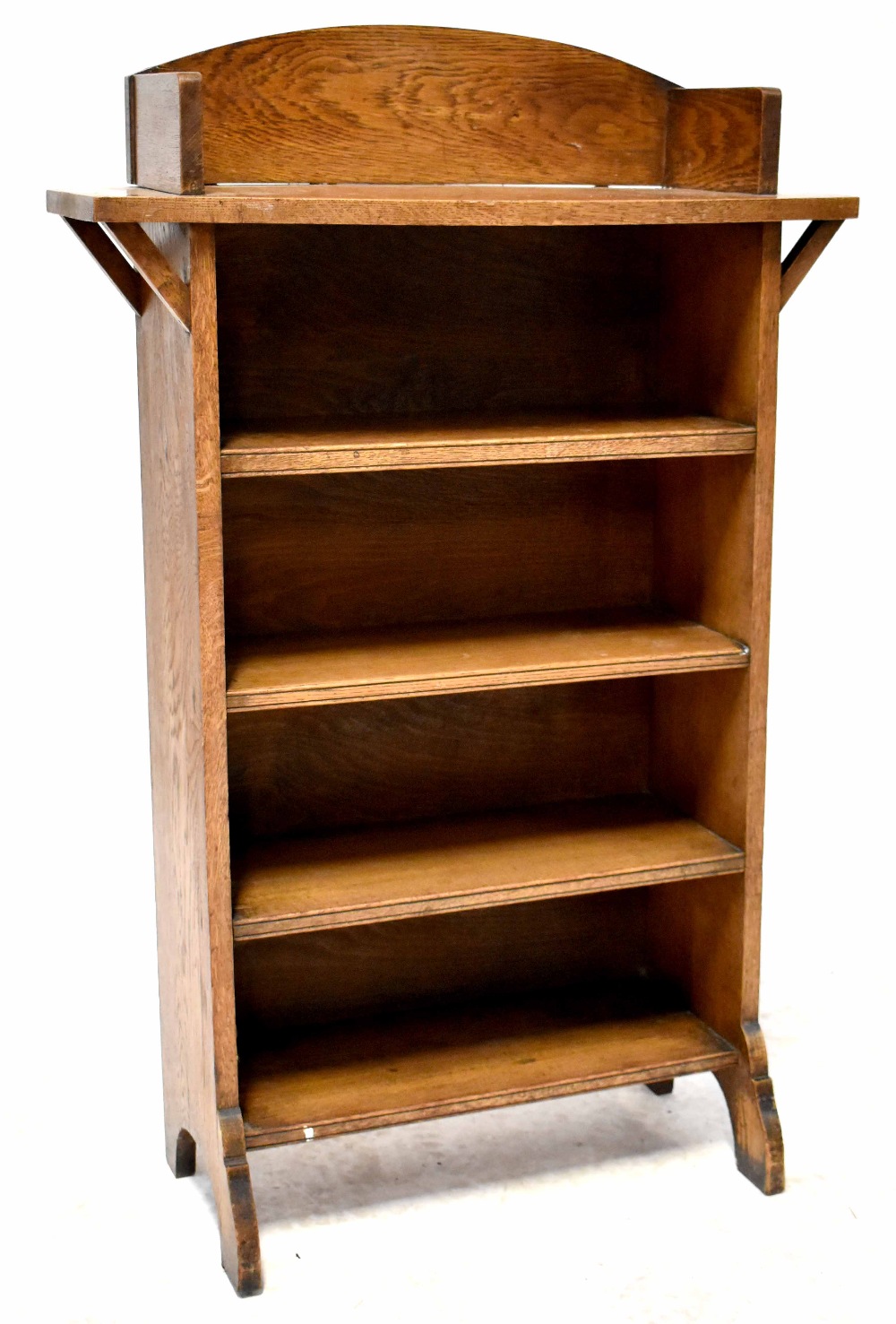 An Arts & Crafts oak floorstanding bookcase with galleried top above five shelves, on stile feet,