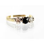 A 9ct yellow gold ladies' dress ring, central sapphire with diamond chip to either side, size I1/2,