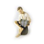 A Bing & Grondahl porcelain model of a seated accordion player, marks to base, numbered '1661 VI',