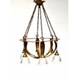 An Arts & Crafts brass ceiling light with six light fittings with glass shades,
