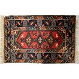An Eastern wool runner with six stylised floral motifs on a central panel,