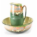 A Royal Doulton jug and bowl painted with sheep on a green and pink ground with trees in the